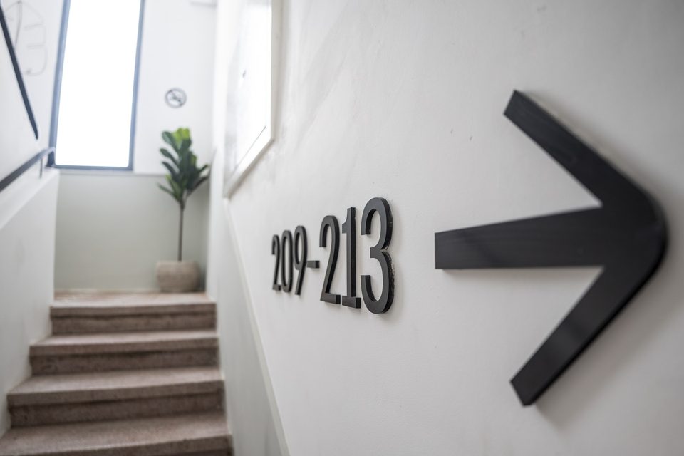 Panneau indiquant les chambres 209–213 dans le couloir de l'hôtel