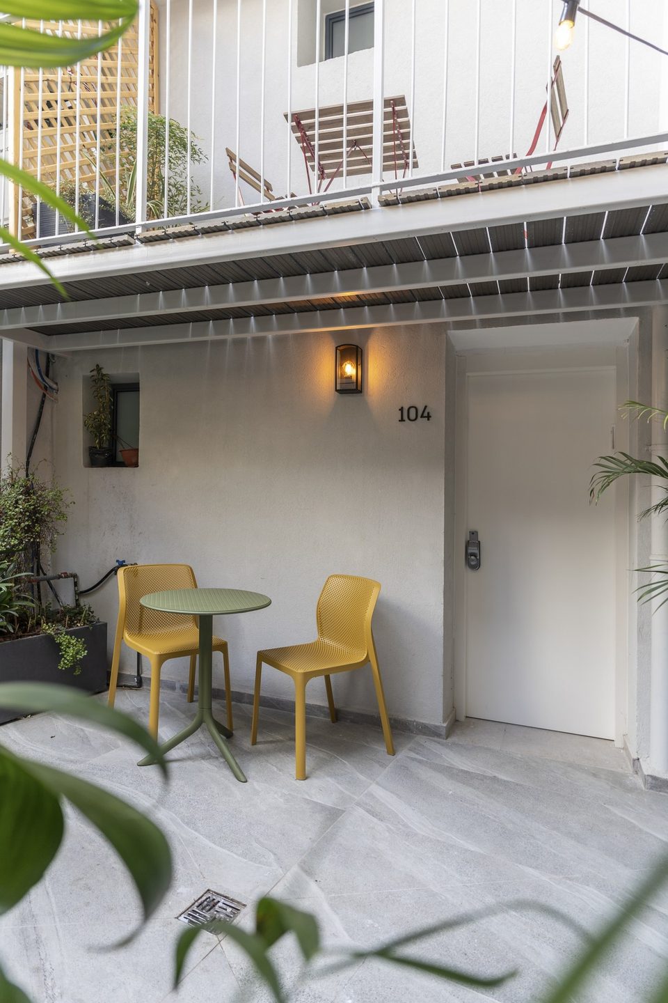 Un coin salon dans la cour près de l'entrée de la chambre 104
