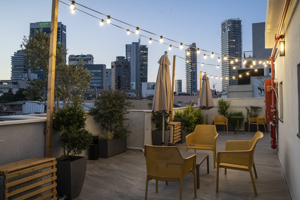 Le toit au crépuscule avec guirlandes lumineuses et tours de Tel Aviv