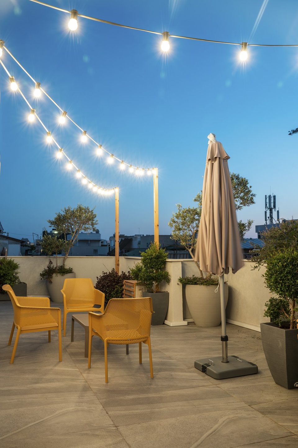 Guirlandes lumineuses et fauteuils sur le toit en soirée