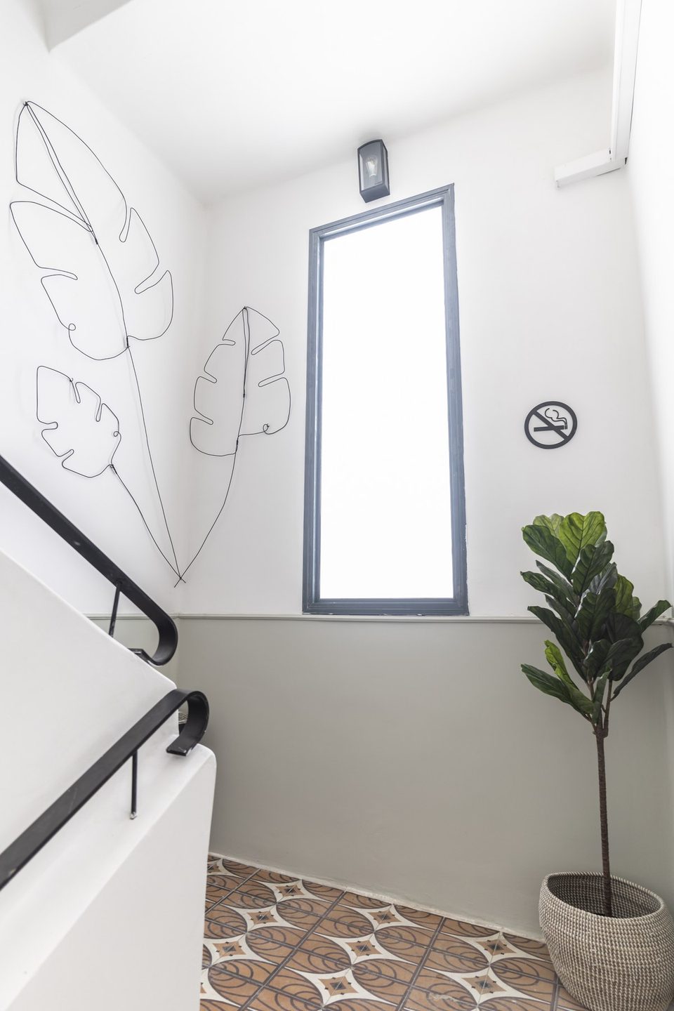 Cage d'escalier lumineuse avec dessin au trait et plante